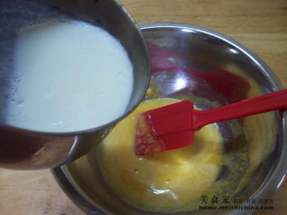 煮沸的牛奶加进蛋黄糊的盆里快速搅拌,防止结
