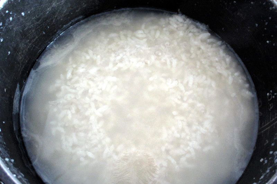 2 把米和适量的水放入电饭锅内,煲白粥.