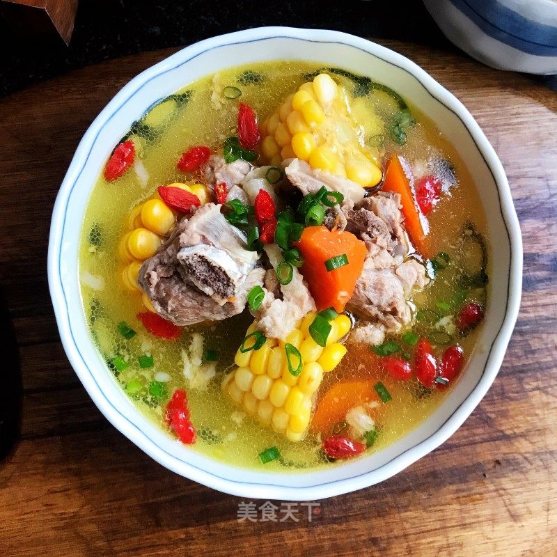 Meat, goji berries, and corn in a yellow broth
