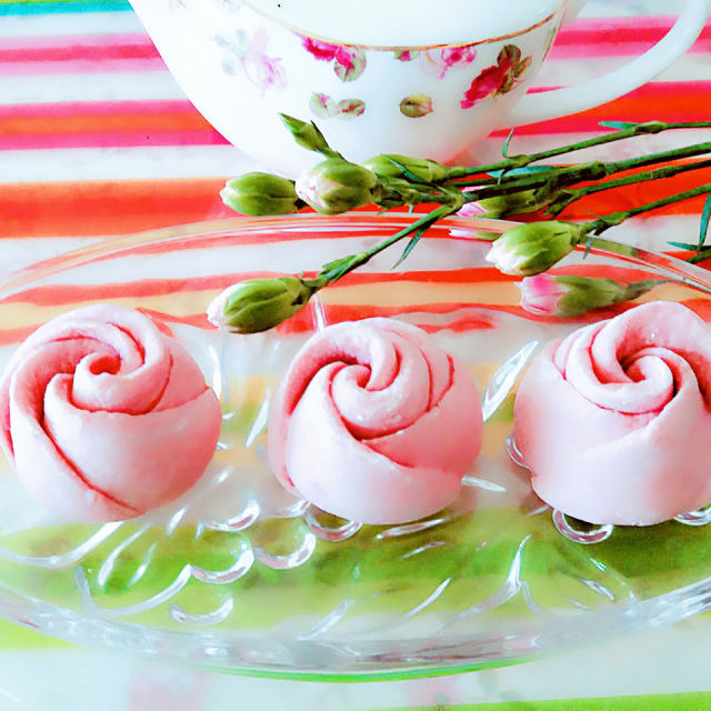 这是一款创意粉玫瑰花它是用火龙果皮榨汁和面制作而成，绿色、天然、营养、美观的象形面食